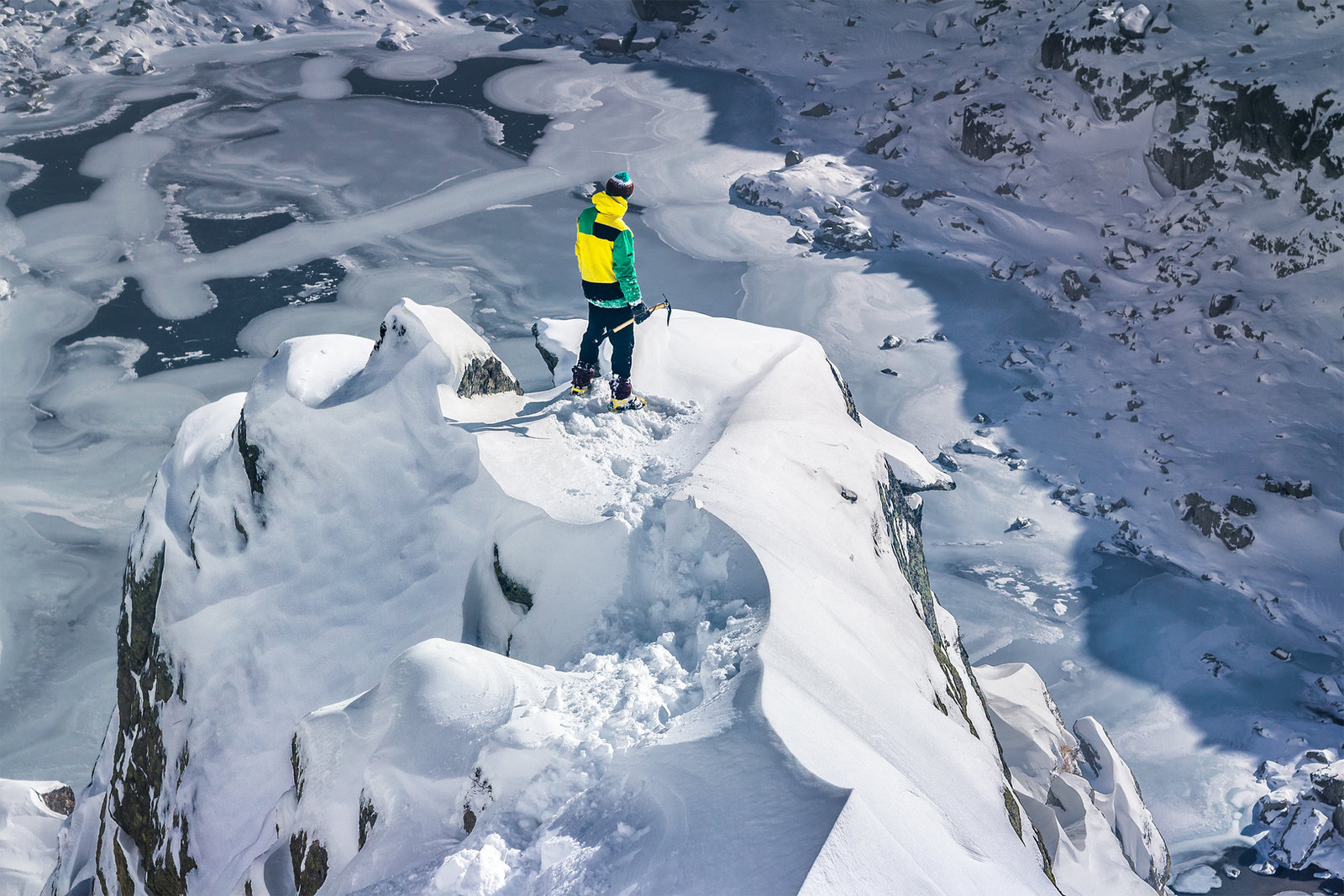 Alpinista no topo de uma montanha coberta de neve